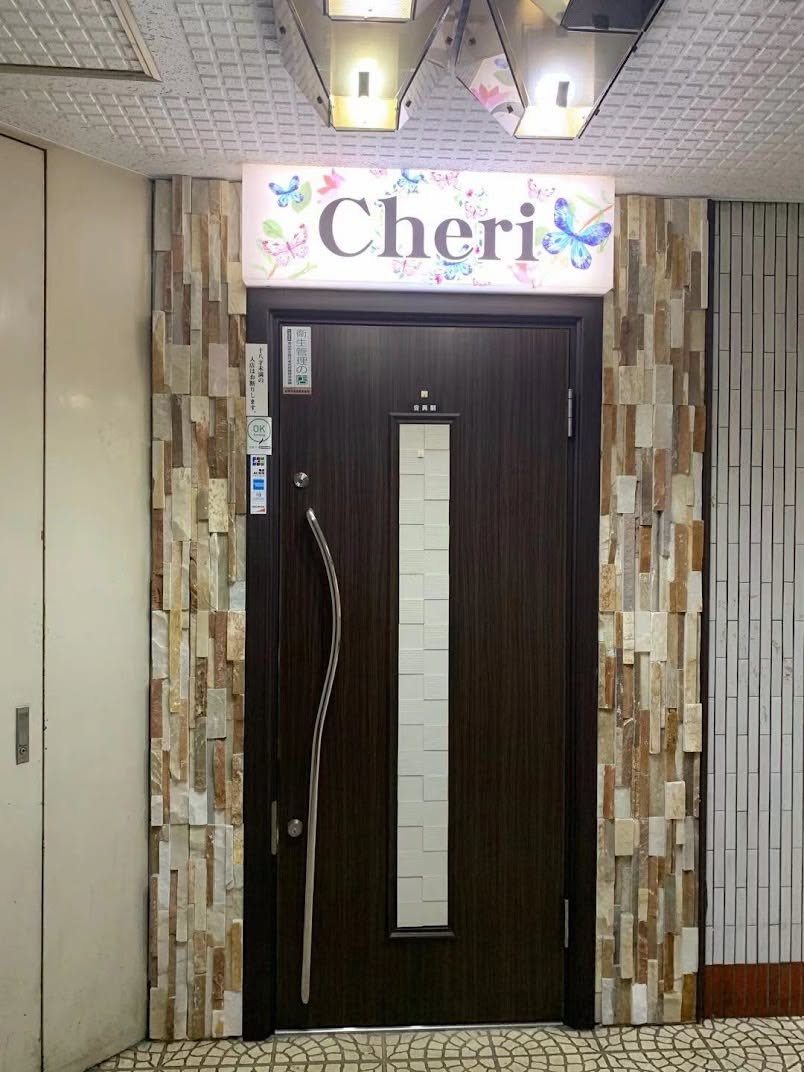 木屋ビル3階にあるCheriの入口。蝶の描かれた看板と扉