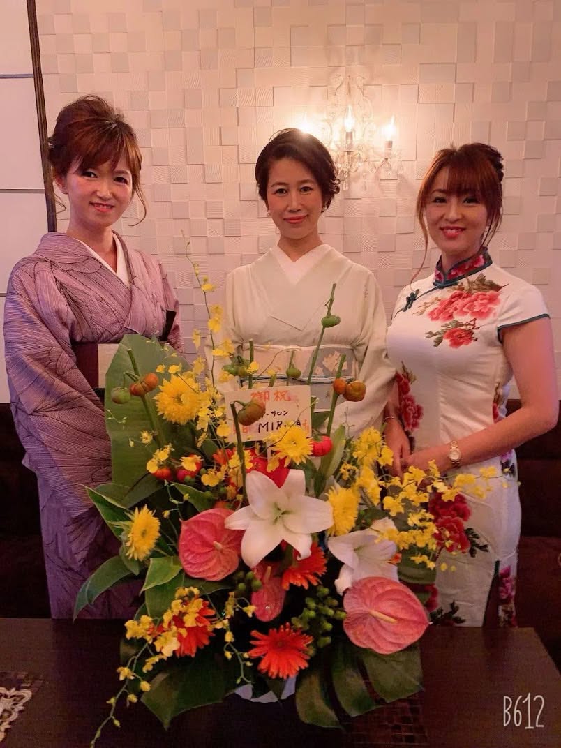 お祝いの花とともに並ぶ、Cheriのママとスタッフ